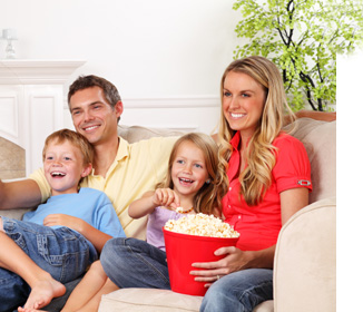 photo of smiling child on lounge with TV in background